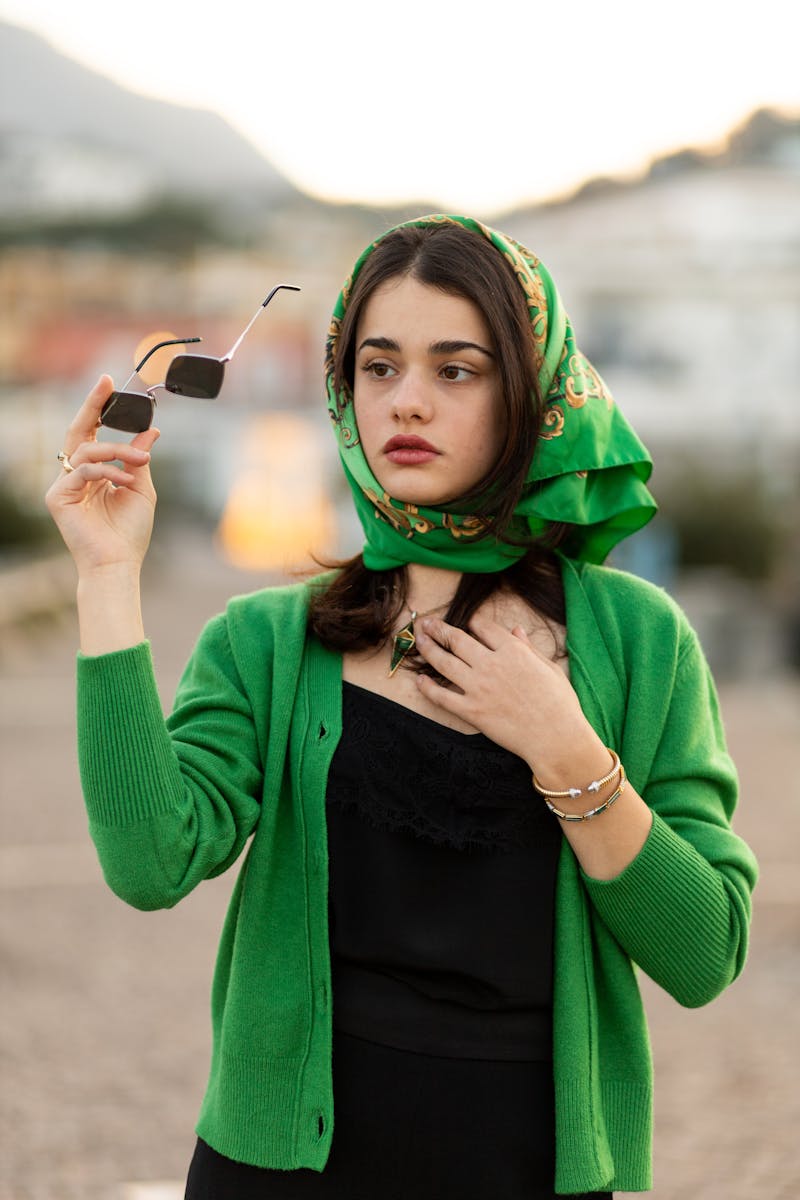 Woman in Green Cardigan Holding a Sunglasses