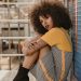 Fashionable portrait of a woman posing with a stylish afro hairstyle outdoors.