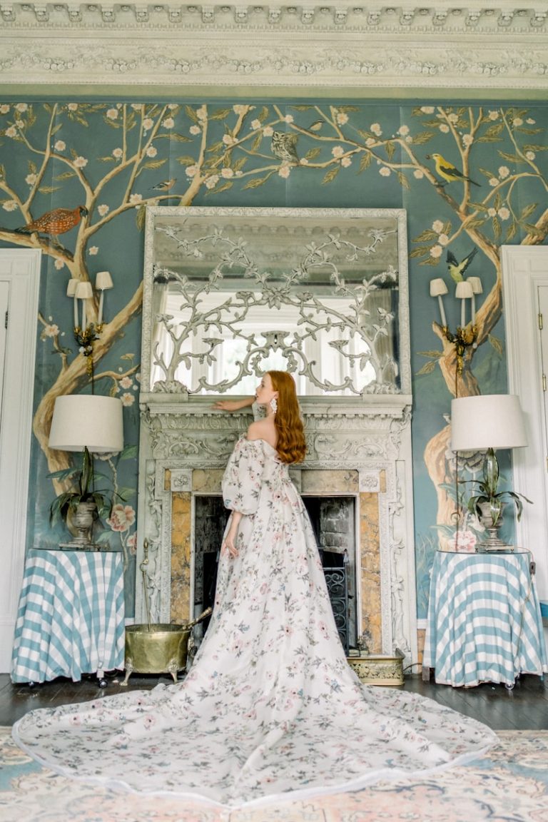 A woman in a dress standing in front of a fireplace